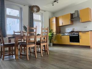 弗赖贝格Bergstadtwohnung的厨房以及带桌椅的用餐室。