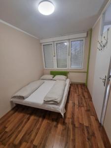 Novi BeogradHawaii 08, 2 bedrooms, with garage的卧室配有一张床、木地板和窗户。