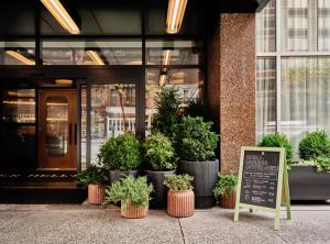 纽约Romer Hell's Kitchen的植物盆栽的建筑物前的标志