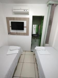 北茹阿泽鲁Hotel Vitoria Iracema的小房间设有两张床和电视