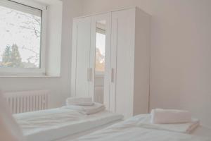 诺伊斯Apartment mit Küche, Arbeitsplatz und XXL Sofa的白色客房内的镜子,配有两张床
