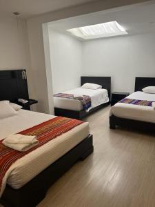 昆卡Hostal Entre Ríos的一间卧室设有两张床和天窗