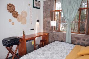巴克里索莫雷诺港Hostal Pimampiro的一间卧室配有一张床、一张书桌和窗户。