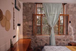 巴克里索莫雷诺港Hostal Pimampiro的卧室设有窗户、窗帘和桌子