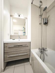 维勒瑞夫Maison de Charme - parking gratuit près de Paris & métro的一间带水槽、浴缸和镜子的浴室