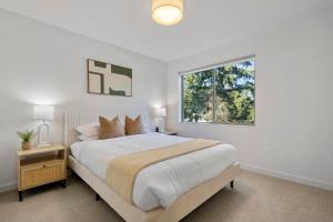 肖尔莱恩New Meridian Park Shoreline WA的白色的卧室设有一张大床和一个窗户