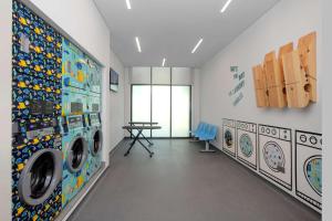 迪拜Rove La Mer Beach, Jumeirah的洗衣房配有洗衣机和桌子