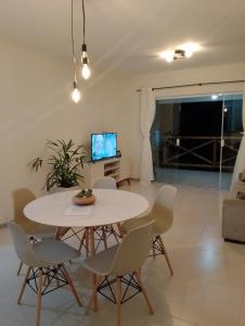 埃斯坦西亚Apartamento no Condomínio Vila das Águas的一间配备有白色桌椅的用餐室