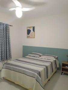 埃斯坦西亚Apartamento no Condomínio Vila das Águas的一间卧室配有一张床和吊扇