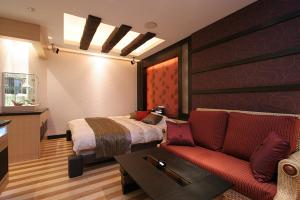 Kurosuホテル　Kirara的一间卧室配有一张床和一张红色的沙发
