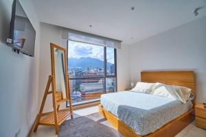 基多Moderna suite en Quito RG的一间卧室设有一张床和一个大窗户