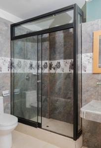 库斯科Samay Business Hotel and Departments的一间带卫生间的浴室内的玻璃淋浴间