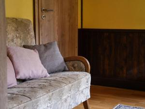 EnnalAttractive Chalet in Vielsalm with Large Garden的一张沙发,上面有两个枕头