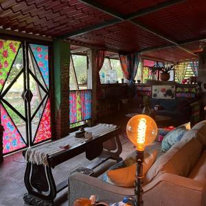 Santa María HuatulcoPlanta Glamp Farm的客厅设有彩色玻璃窗和桌子
