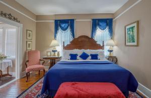 圣奥古斯丁Victorian House Bed and Breakfast的一间卧室配有蓝色的床和蓝色窗帘