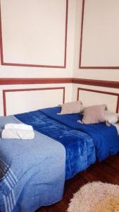 布宜诺斯艾利斯Dante y compañia的配有两张床铺的蓝色床单和枕头