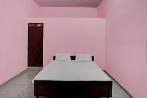诺伊达OYO Hotel star palace的粉红色客房内的一间卧室,配有一张床