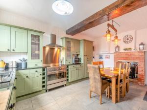 East FerryThe Gatehouse的厨房配有绿色橱柜和木桌