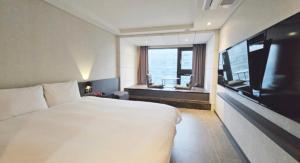 济州市Air City Hotel Corp的酒店客房设有一张大床和一台电视。