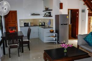 帕干岛Baan Chom Chan的厨房以及带桌子和冰箱的客厅。
