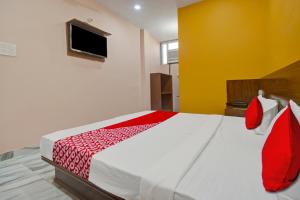 斋浦尔Hotel Rameshwaram的一间卧室配有一张带红色和白色床单的大床