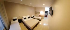 伊瓜苏港安固宾馆的客房设有床、沙发和电视。