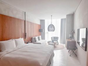 礁溪了了礁溪 Vivir Jiaoxi Hotel的一间带白色大床的卧室和一间客厅