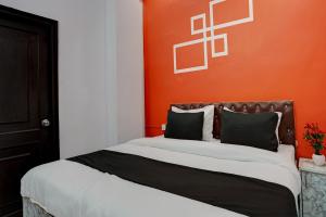 加济阿巴德Garima Garden Townhouse的一间卧室配有一张带橙色墙壁的大床