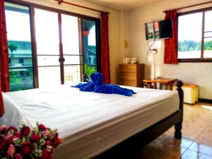 卡塔海滩Kata Lina guesthouse的一间卧室设有一张大床和大窗户