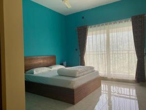 瓦加蒙Earth Lounge Resort的一间卧室配有一张蓝色墙壁的床