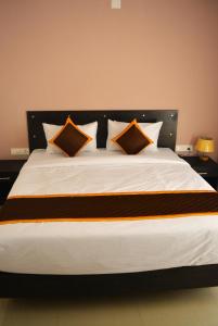 苏丹巴特利NEW MOUNT RESIDENCY的一张带三个枕头的大白色床