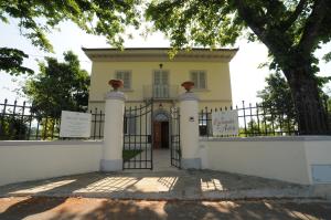 斯卡尔佩里亚La Locanda di Adele - Il Giardinetto B&B的白色的房子,有门和树