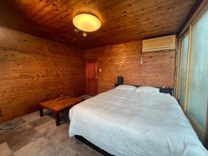 关市HOTEL1800的卧室配有白色的床和木墙