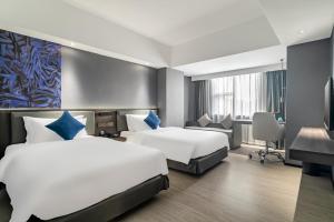 广州迎商酒店(广州广园新村景泰步行街店)的酒店客房配有两张床和一张书桌