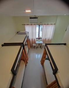 莫阿尔博阿CheRi Backpackers Hostel的客房设有两张床、一张桌子和一扇窗户。