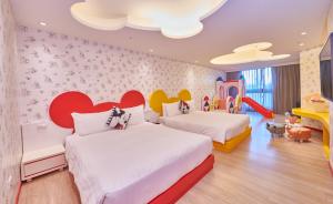 恒春古城垦丁怡湾渡假酒店的儿童卧室内的两张床,墙上有心