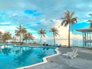 狮子乡垦丁茉莉湾海景渡假酒店  的一座棕榈树游泳池和一座房子