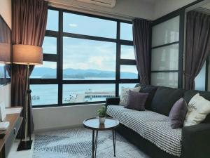 哥打京那巴鲁J'Stay Seaview Suite Jesselton Quay Kota Kinabalu的带沙发和大窗户的客厅