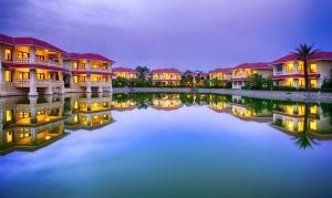 拉杰果德丽景湾酒店泻湖度假酒店的隔着水体在晚上一排房子