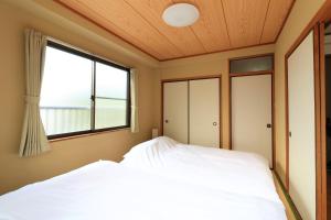 东京Maison Yachiyo 43m2 1 bedroom apartment的一间卧室设有一张床和一个窗口