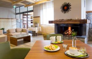 兹雷切Hotel Natura的一间带桌子和壁炉的用餐室