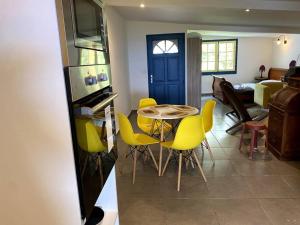 圣若瑟Studio gadiamb的厨房以及带桌子和黄色椅子的用餐室。