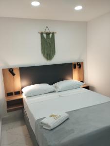 麦德林Zamá Room Hotel的卧室配有一张带两个枕头的大白色床