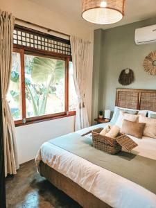 卢纳将军城Greenhouse Siargao Eco-Beach Resort的一间卧室设有一张大床和大窗户