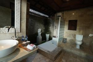 乌布New Mumbul Ubud的带浴缸、盥洗盆和卫生间的浴室
