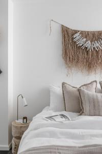 凯阿玛Oceanview Kiama Luxury Coastal Accommodation的卧室配有白色床和编织床头板