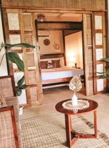 卢纳将军城Greenhouse Siargao Eco-Beach Resort的一间客房内配有床和桌子的房间