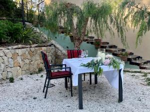 艾格芬卡艾尔奥特罗住宿加早餐旅馆的一张带白色桌布的桌子和两把带鲜花的椅子