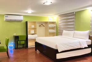 达古潘Damara Hotel at Ciudad Elmina的一间卧室设有一张床和绿色的墙壁