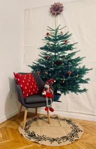 埃格尔Forst-Ház Apartman的客厅里种着圣诞树,配有椅子